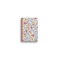 A6 notebook with white background and colourful floral patterns. The book has a pink spine.