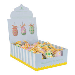A pastel display box labelled ‘Fragments of Fashion’ containing handmade fabric Easter egg decorations in various colourful patterns, each topped with a striped ribbon for hanging.