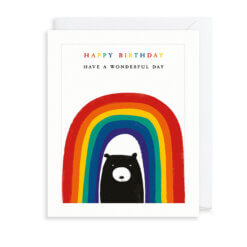 A black bear under a large, colourful rainbow. Above the rainbow is rainbow coloured text reading 'Happy Birthday' above further text reading 'Have a wonderful day'.