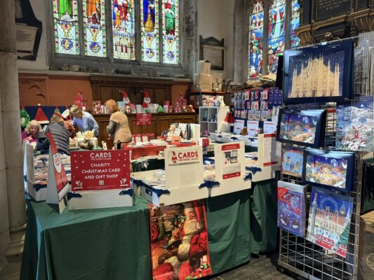 Christmas cards, advents and gifts on display in a church.