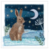 Fabric collage of a brown hare under a crescent moon and stars on a blue night sky