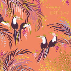 A square card with a peach coloured background and gold text in the corner reading 'happy birthday'. Five toucans with colourful feathery tails are perched on the branches of trees which have colourful leaves in purple, yellow, gold and blue.